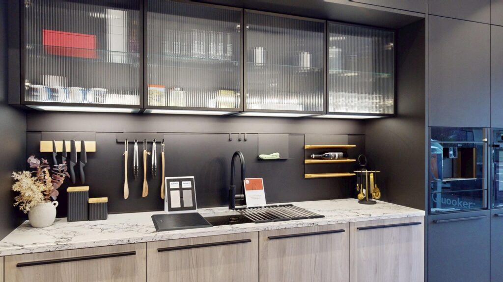 Bright handleless kitchen with white worktops, integrated ovens and natural wood flooring