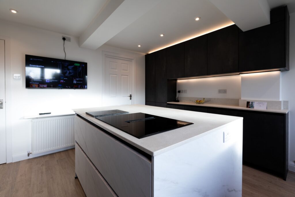 Modern black and white kitchen with island hob and LED lighting