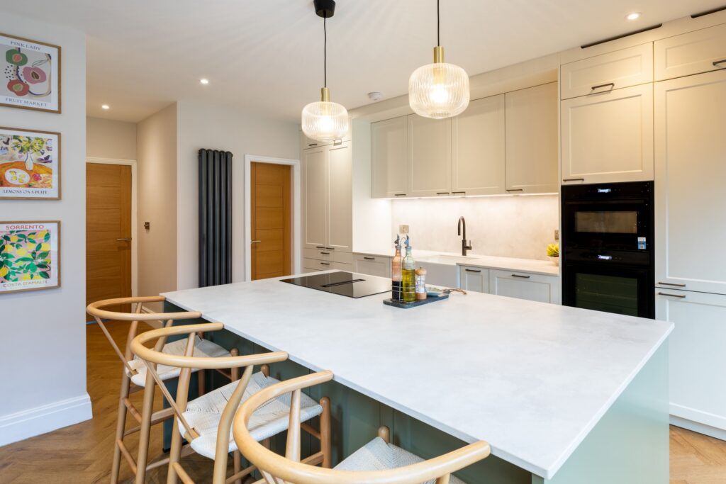 Open-plan Suga Küchen island kitchen with seating, pendant lights and integrated appliances