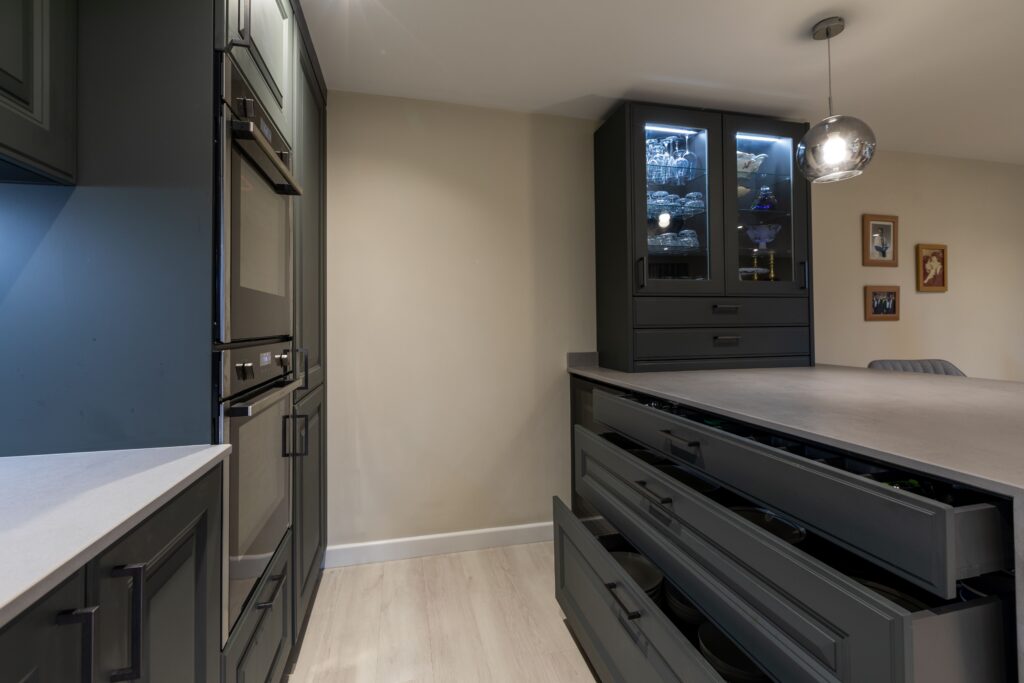 Dark kitchen cabinetry with full-extension drawers and built-in appliances
