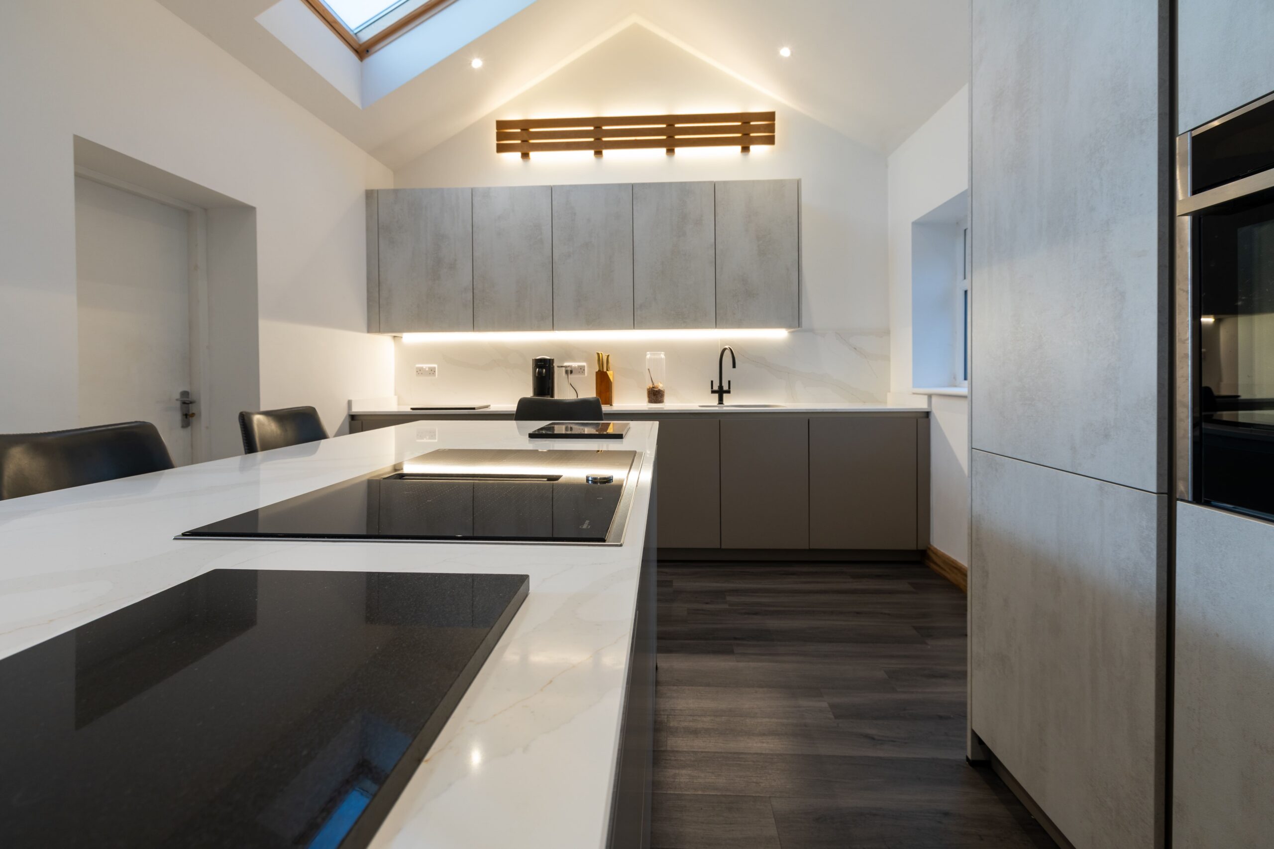 Modern German kitchen with grey handleless cabinets and island, showcasing practical kitchen layout planning and workflow design